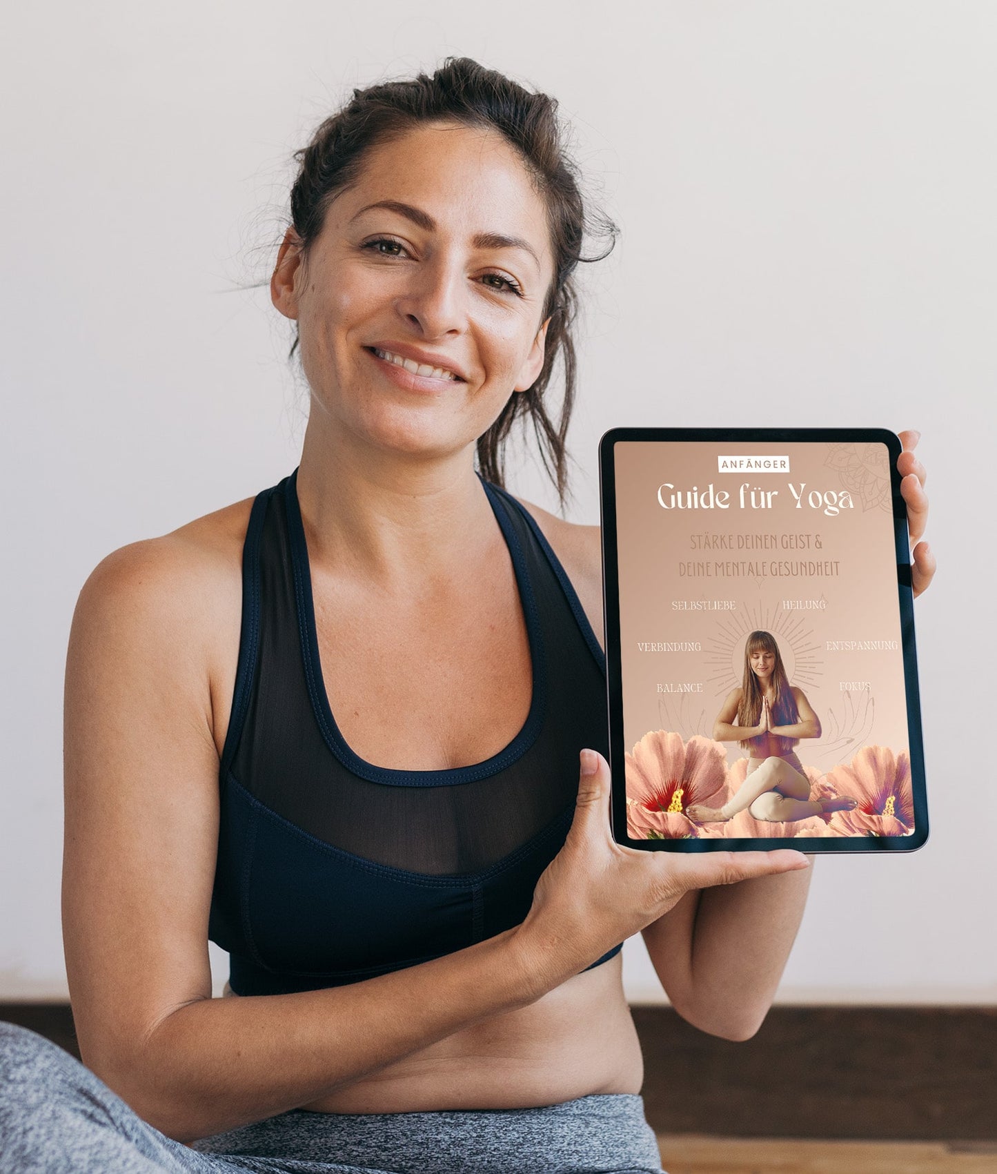 Model hält Yoga Anfänger Guide Ebook auf Tablet 